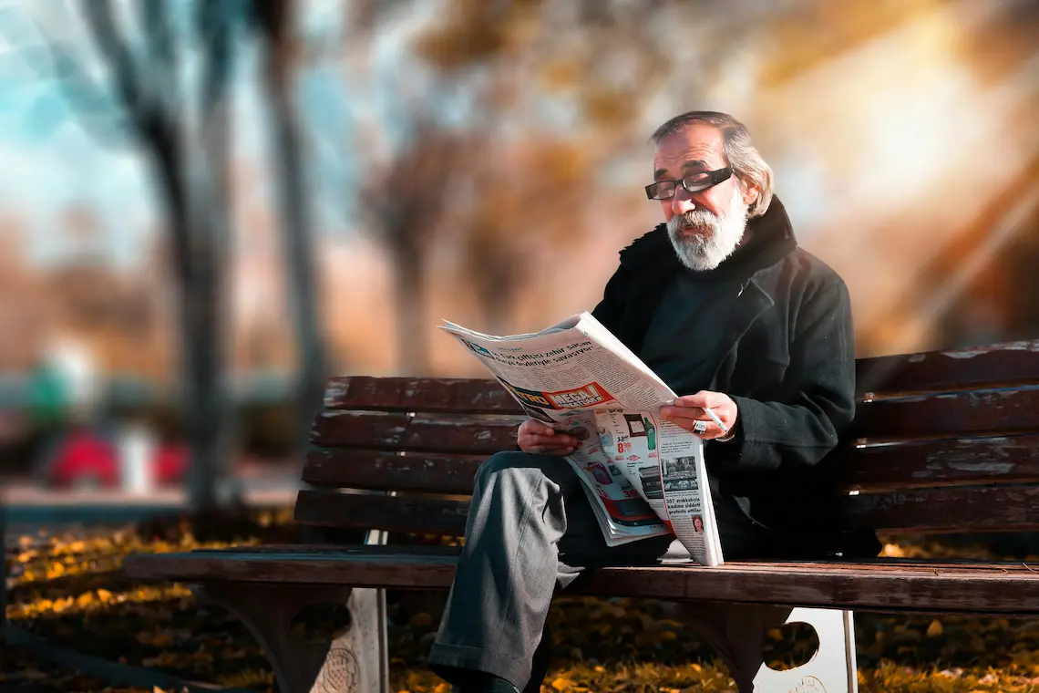 Homem idoso lendo um jornal, representando envelhecimento com boa cognição.