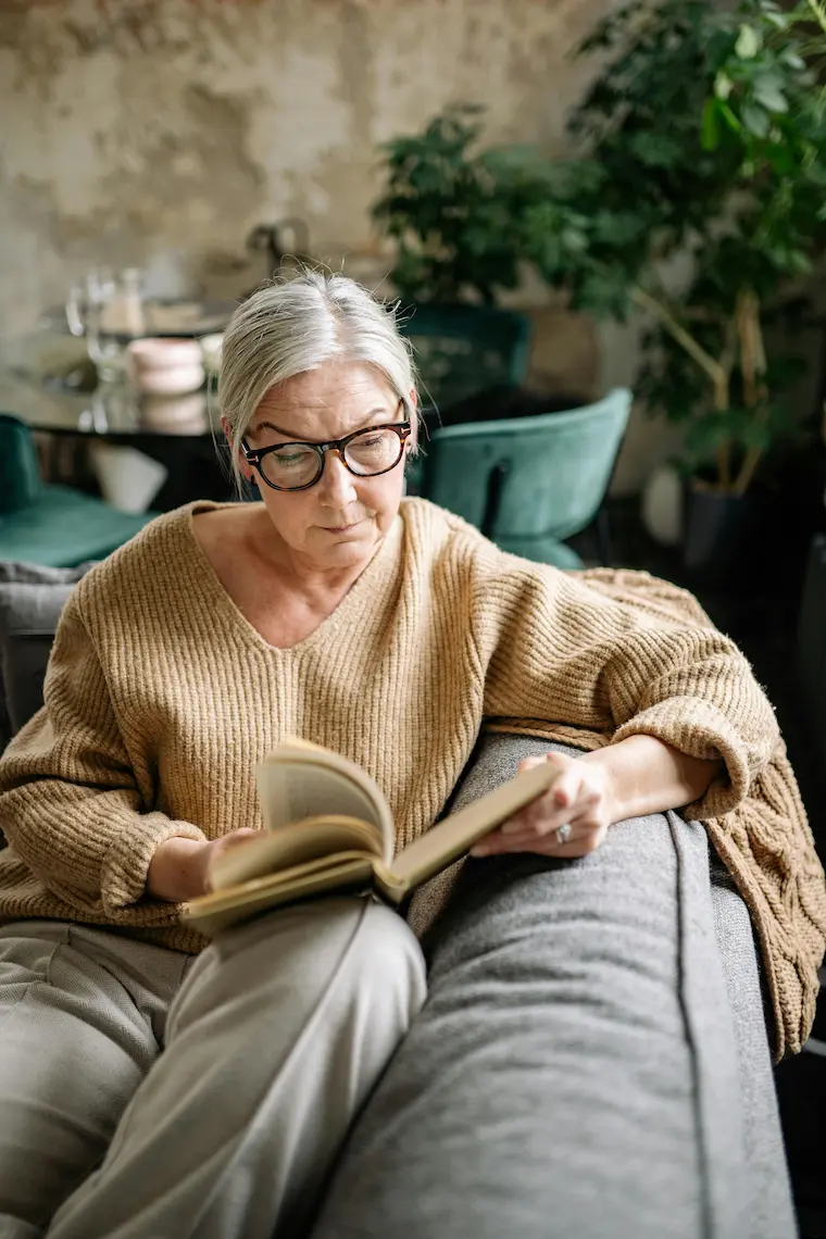 Mulher idosa lendo um livro, representando envelhecimento com boa cognição.